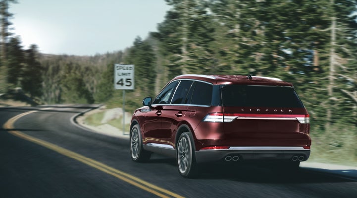 A 2024 Lincoln Aviator® SUV is being driven on a winding mountain road | Ed Morse Lincoln in Muscatine IA